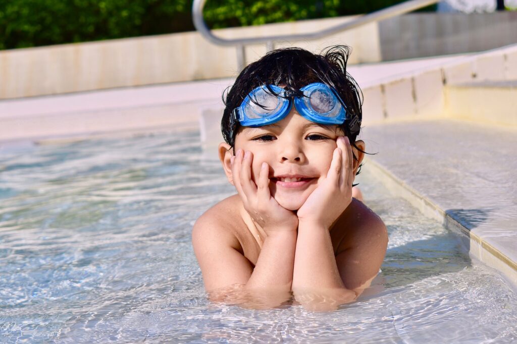 boy in a pool with goggles on head