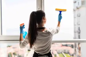 woman washing window from behind